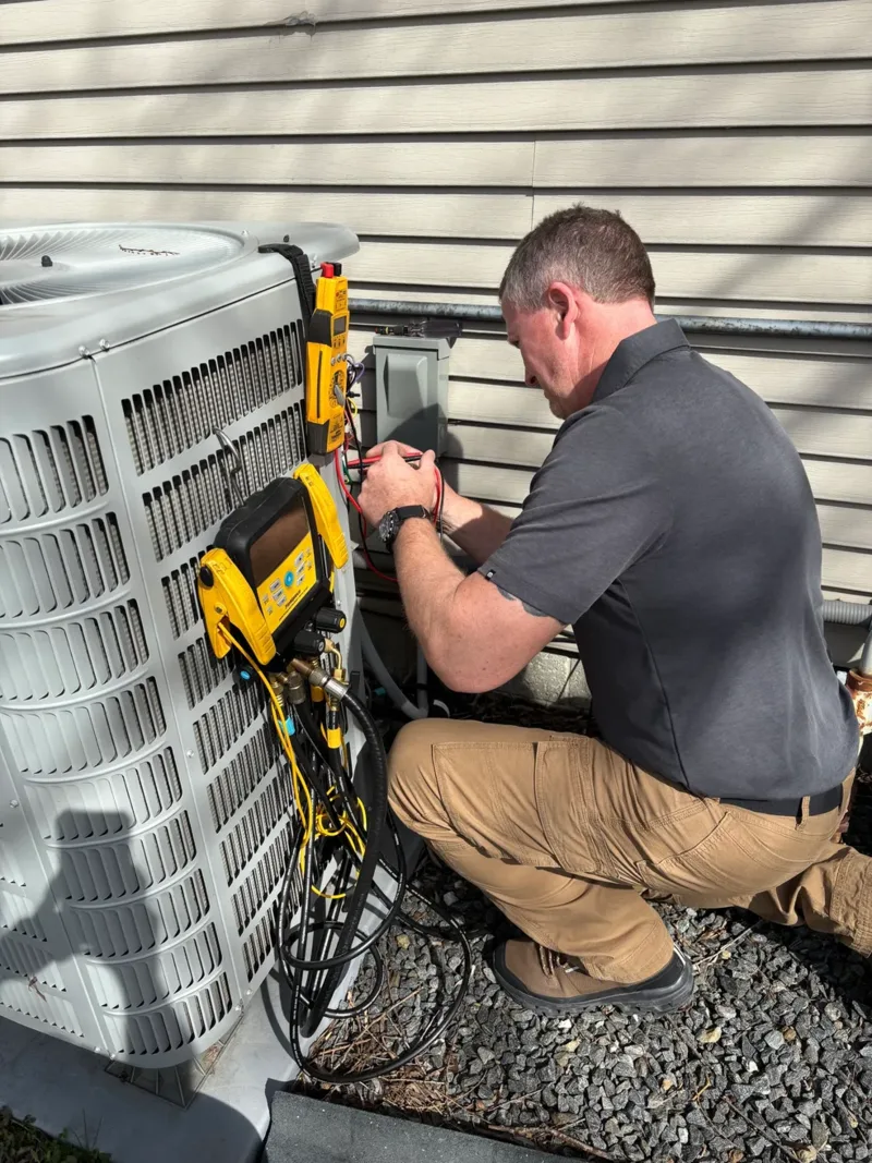 Summit Comfort Solutions HVAC technician servicing an outdoor air conditioning unit